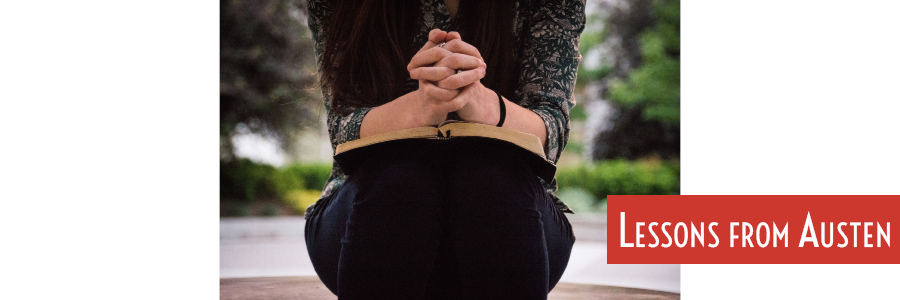 book open on woman's lap, hands clasped with fingers interlaced