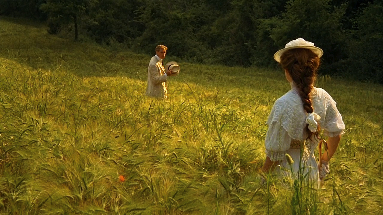 still from the 1985 film A Room With A View, Lucy and George standing in the open field above Florence